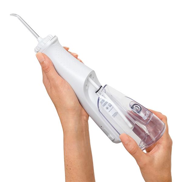 Sliding the water reservoir to remove it from the White Cordless Plus 5000 water flosser handle.