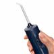 Blue Cordless 1000 handheld water flosser handle, shown held in a hand for scale.