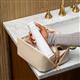 Hydropulseur portatif sans fil Plus 5000 blanc, sans embout, sorti d’une trousse de toilette.