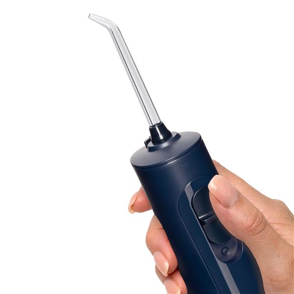 Manche de l’hydropulseur portatif sans fil 1000 bleu, tenu dans une main pour donner l’échelle.